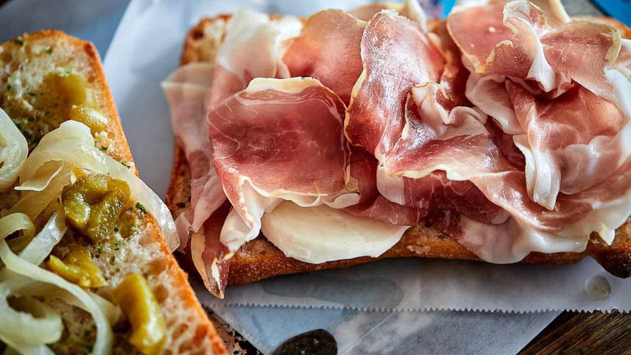 two slices of bread with meat and cheese on them