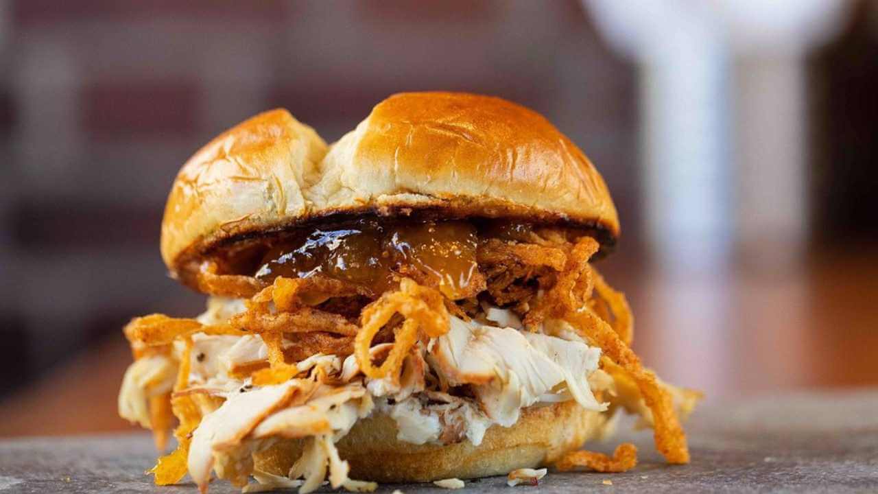 a close up of a pulled pork sandwich on a bun