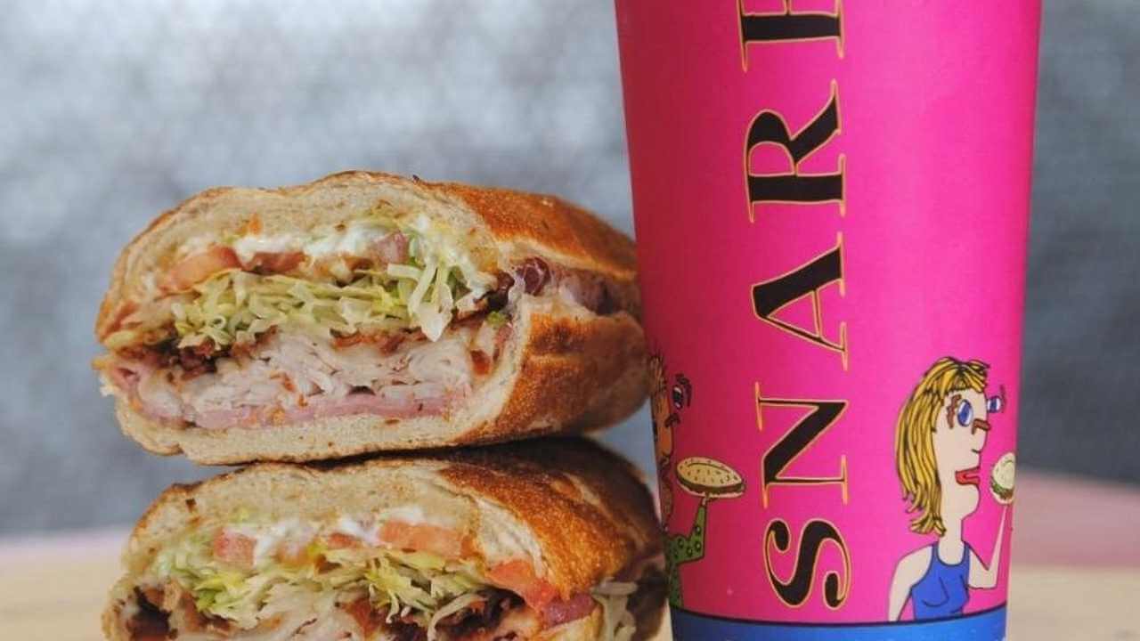 a sandwich sitting next to a cup of coffee