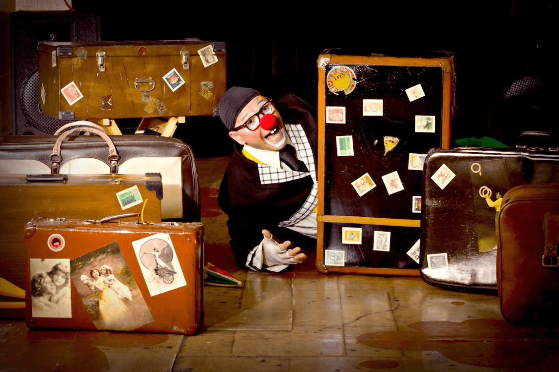 A clown and many suitcases