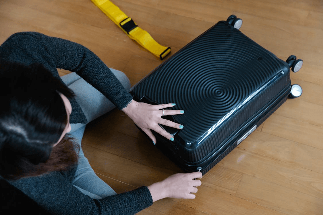 Person zipping a suitcase