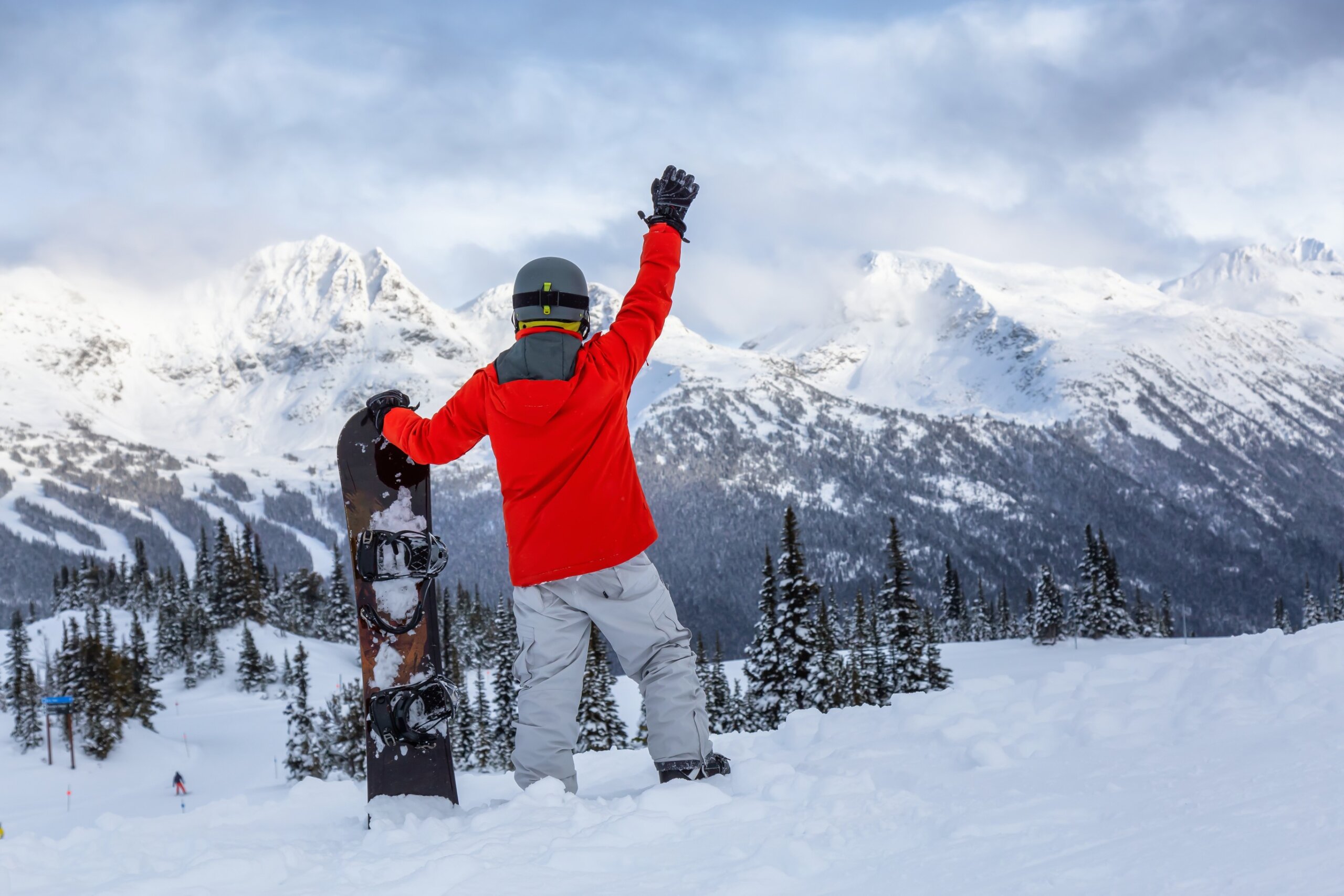 Male Snowboarder is riding down a ski run in wintertime. Taken on Whistler Mountain, British Columbia, Canada.
