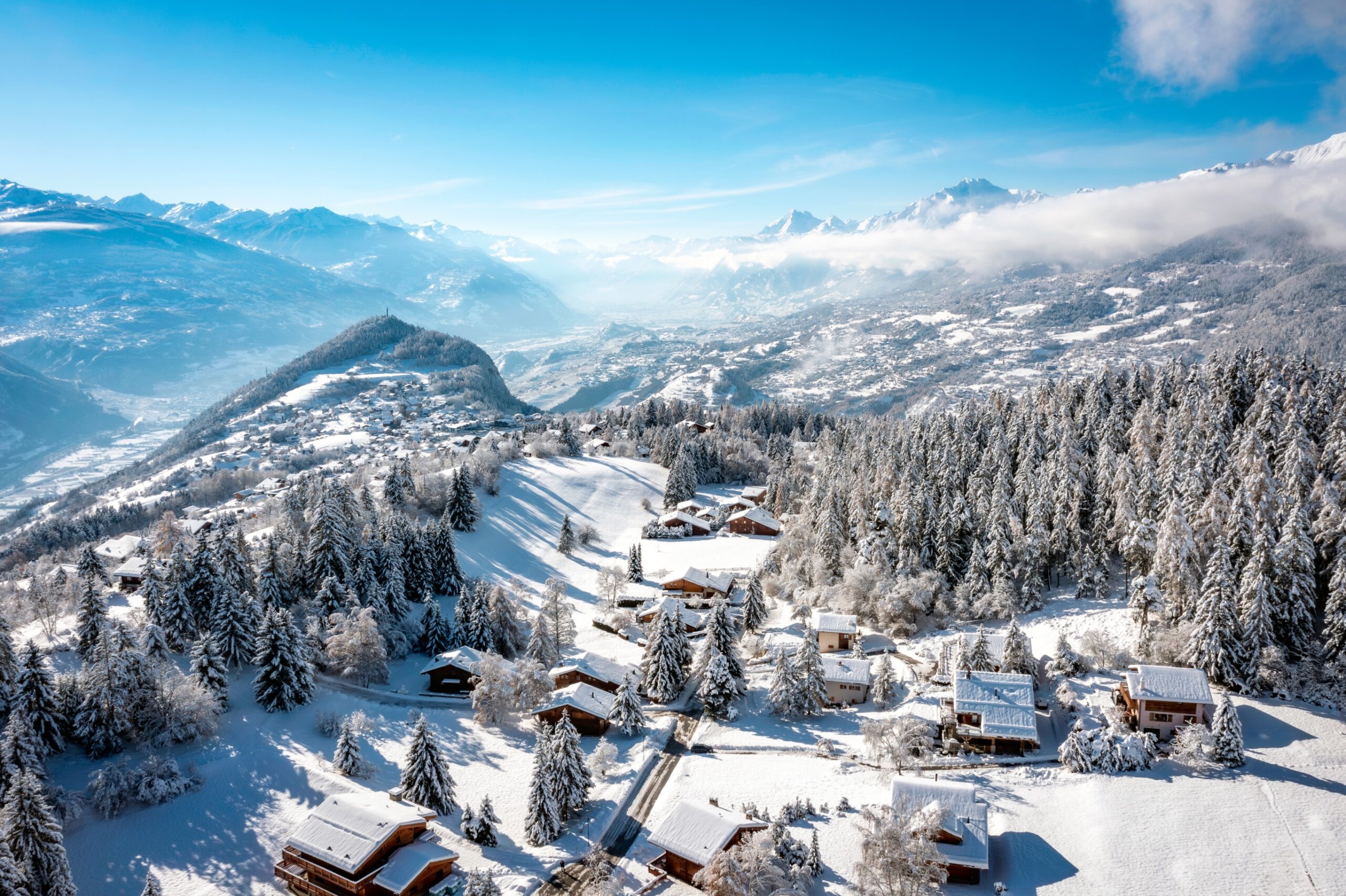 The Rhone valley in winter, in the Valais Alps, Switzerland from Crans-Montana ski resort with the villages of Lens, Icogne, Ayent and the town of Sion.