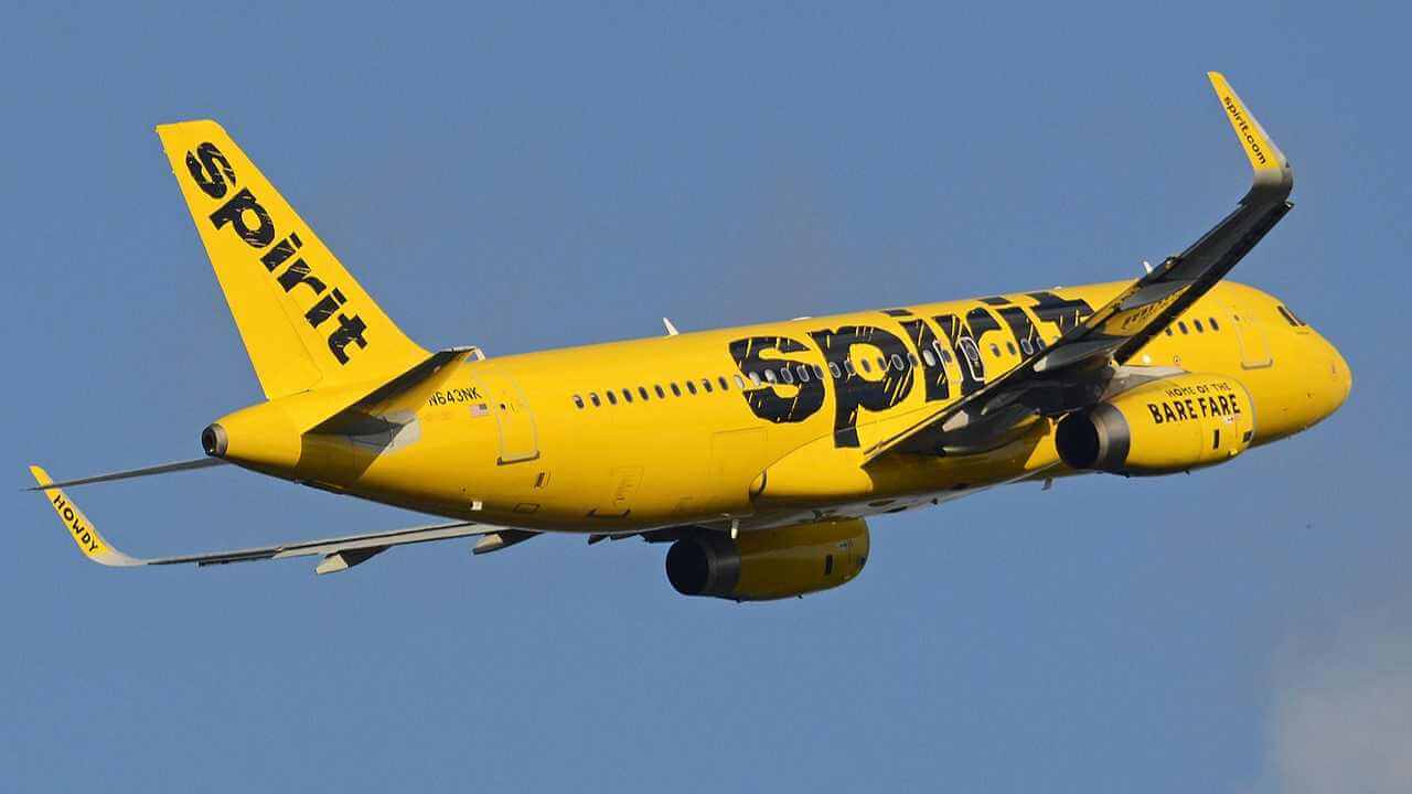 the spirit airlines plane is flying in the sky