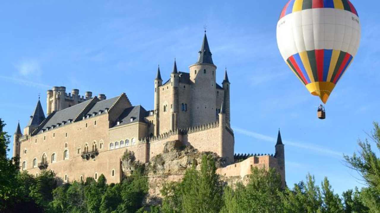 a large castle with a hot air balloon flying over it