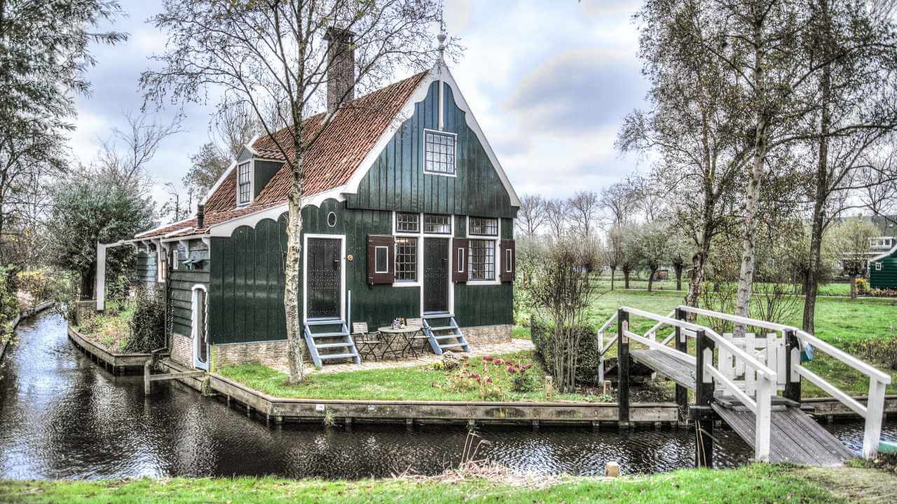 a house on the water with a bridge over it