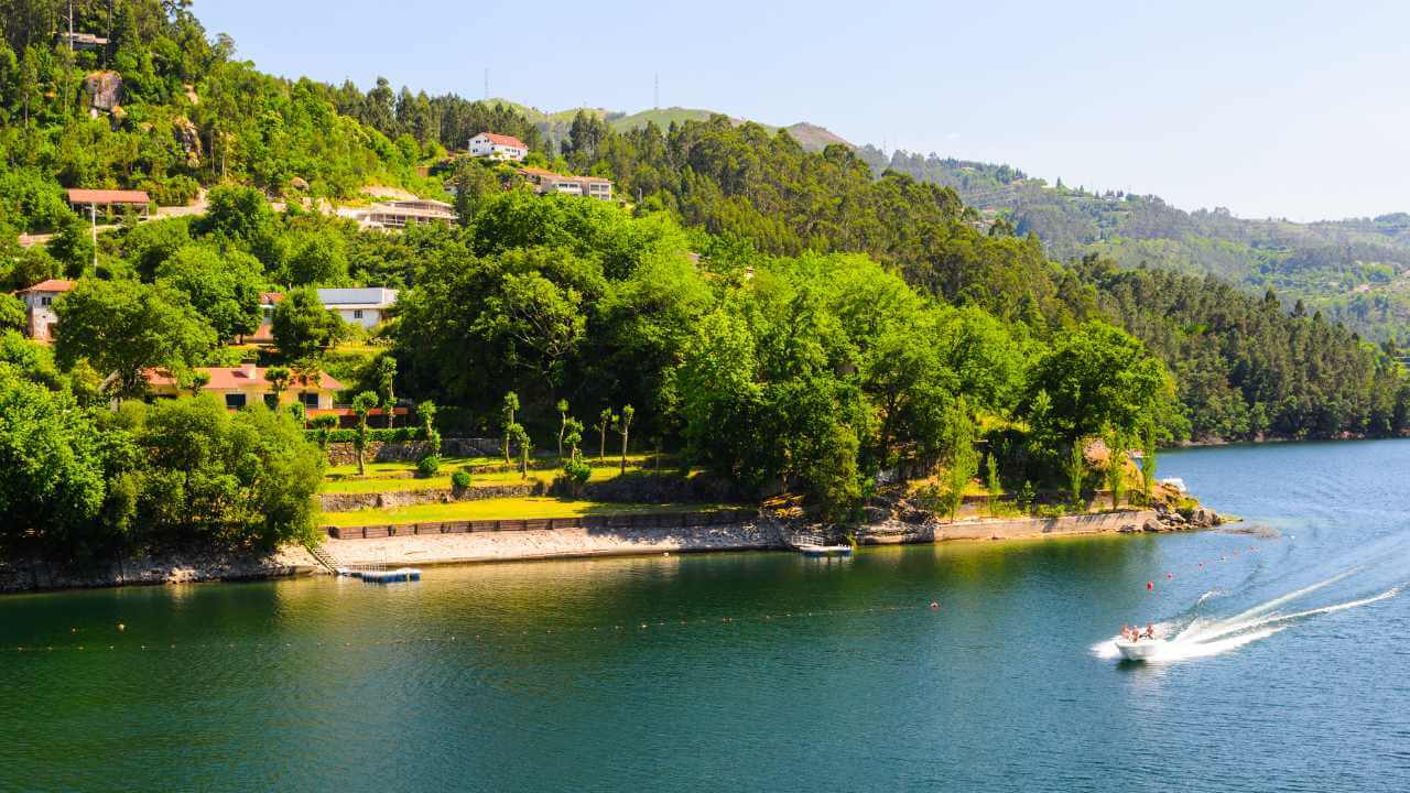 a boat on a lake surrounded by lush green hills