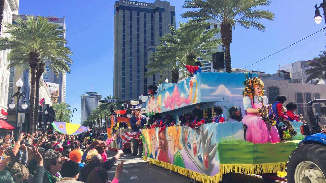 a parade float with people on it and palm trees in the background