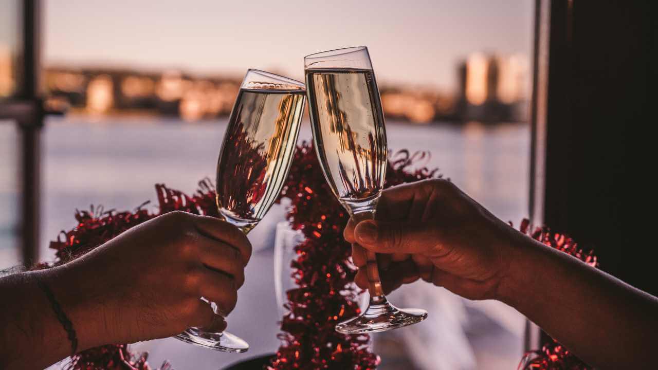 two people toasting with champagne glasses in front of a city skyline