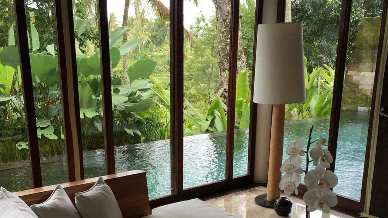 a living room with large windows overlooking a pool