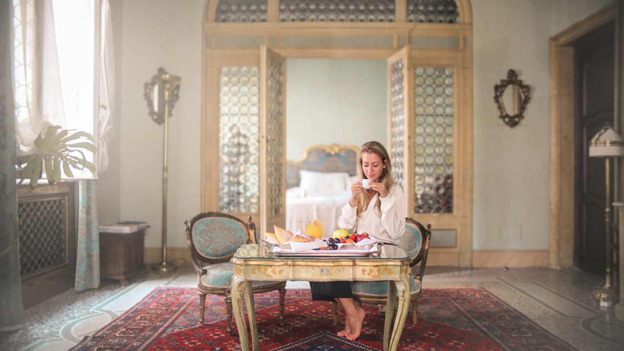 a person sitting at a table with food and drinks