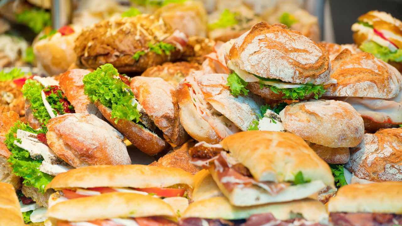 many different types of sandwiches on display in a buffet