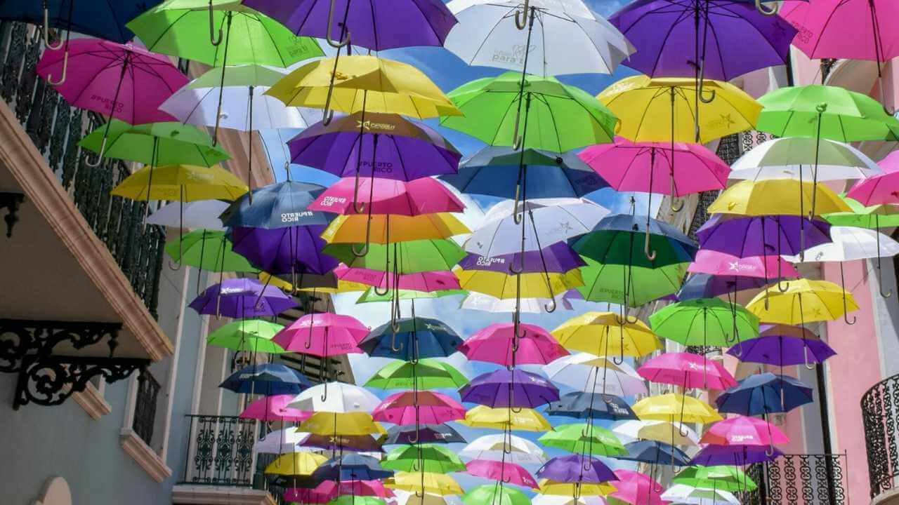 many colorful umbrellas hanging from the ceiling