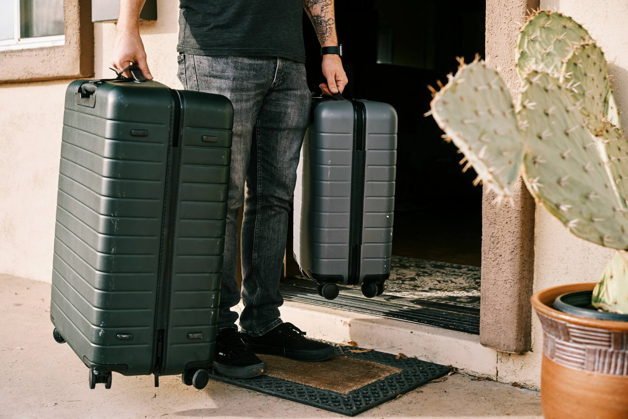 Traveler holding suitcases while learning how to pack light and avoid overpacking when traveling