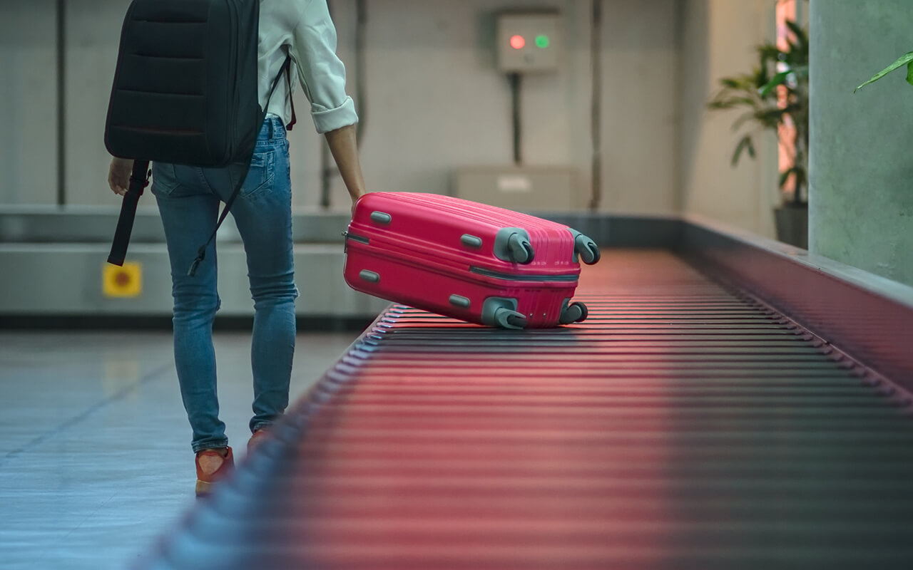 Traveler grabbing checked luggage