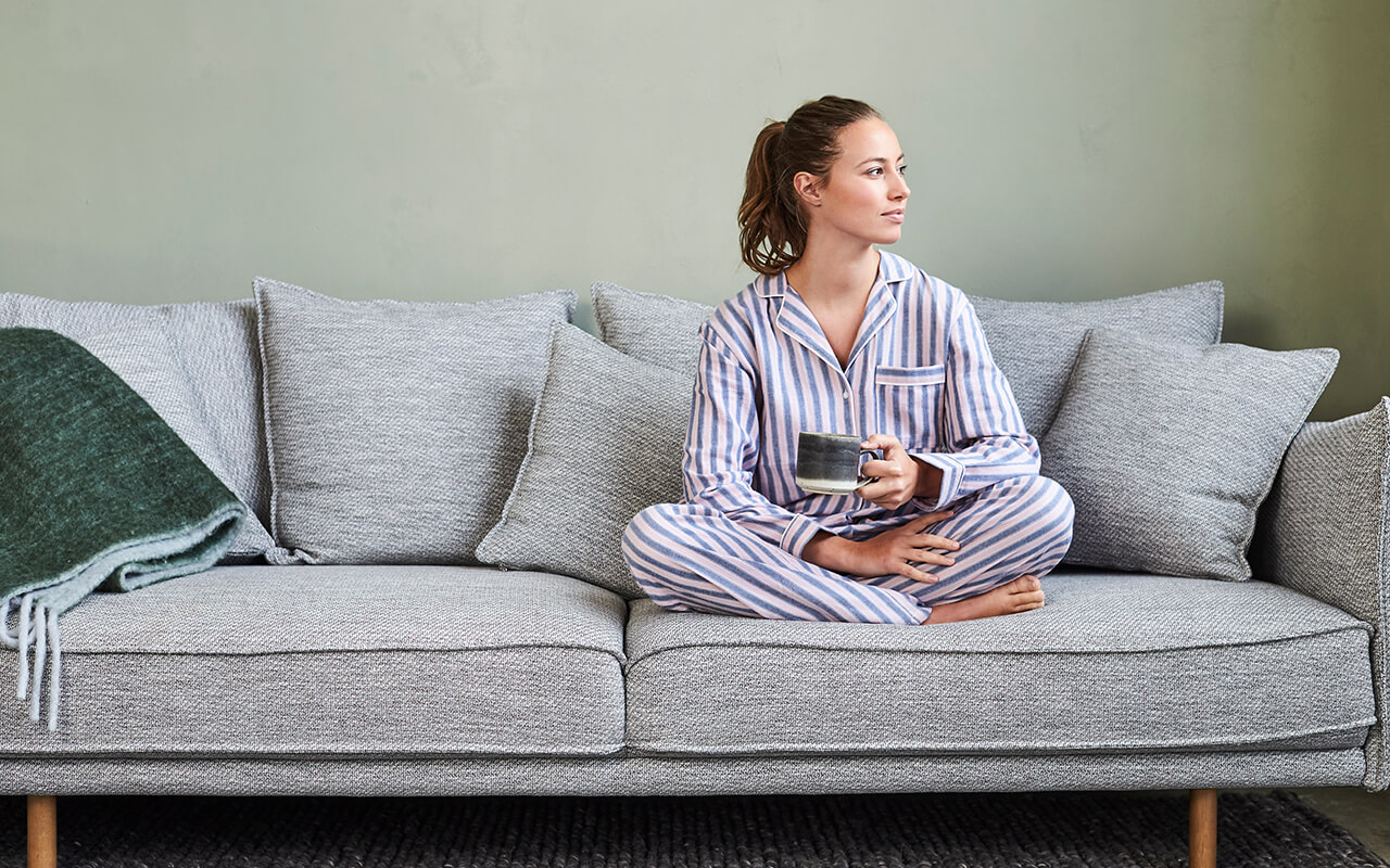 Woman sitting on a couch in pajamas 