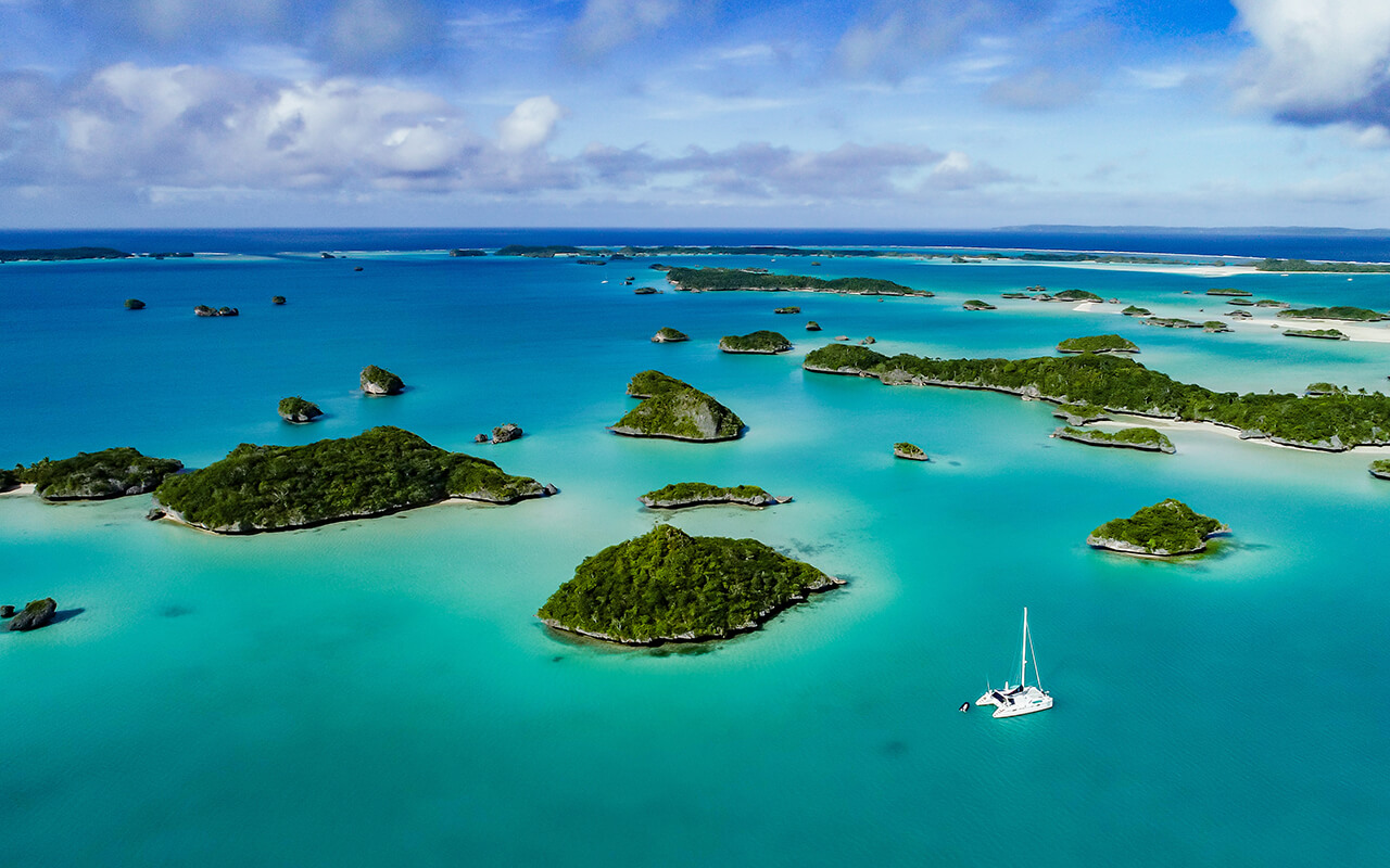 A spectacular drone image over Falaga Island in the lower Lau Group, Fiji showing a catamaran peacefully at anchor.