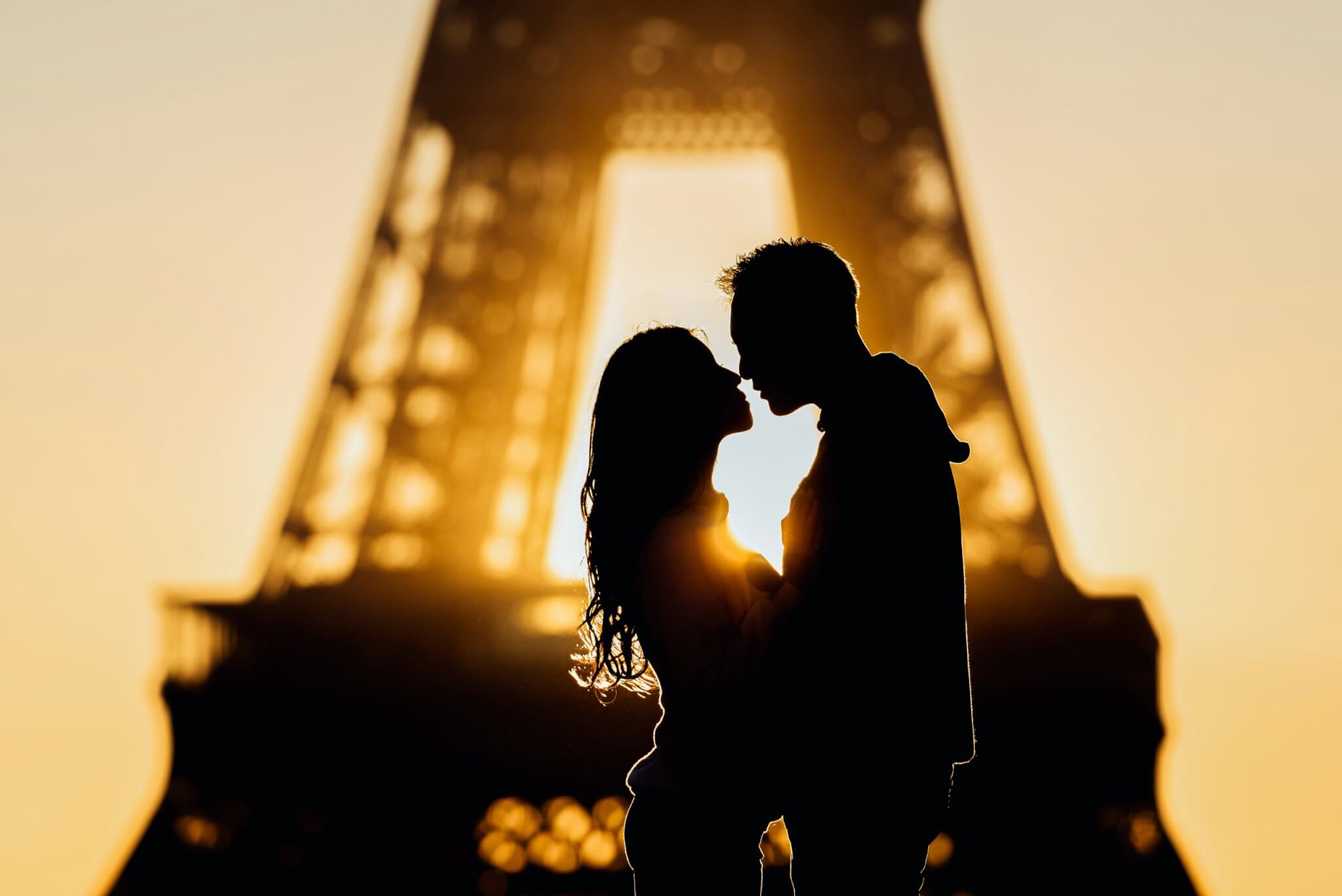 couple kissing near the eiffel tower