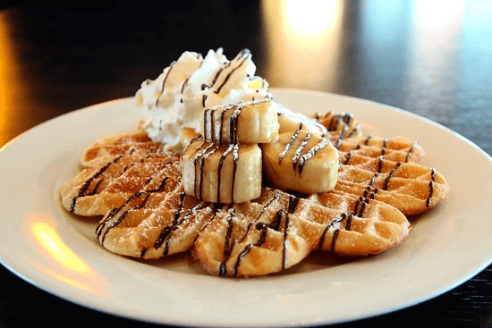 Waffles topped with bananas and chocolate
