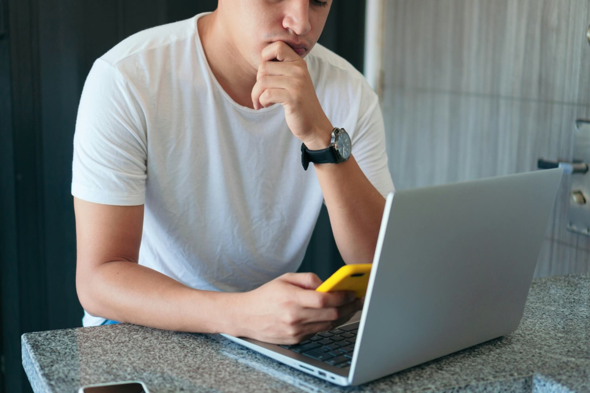 Man using a smartphone and laptop 