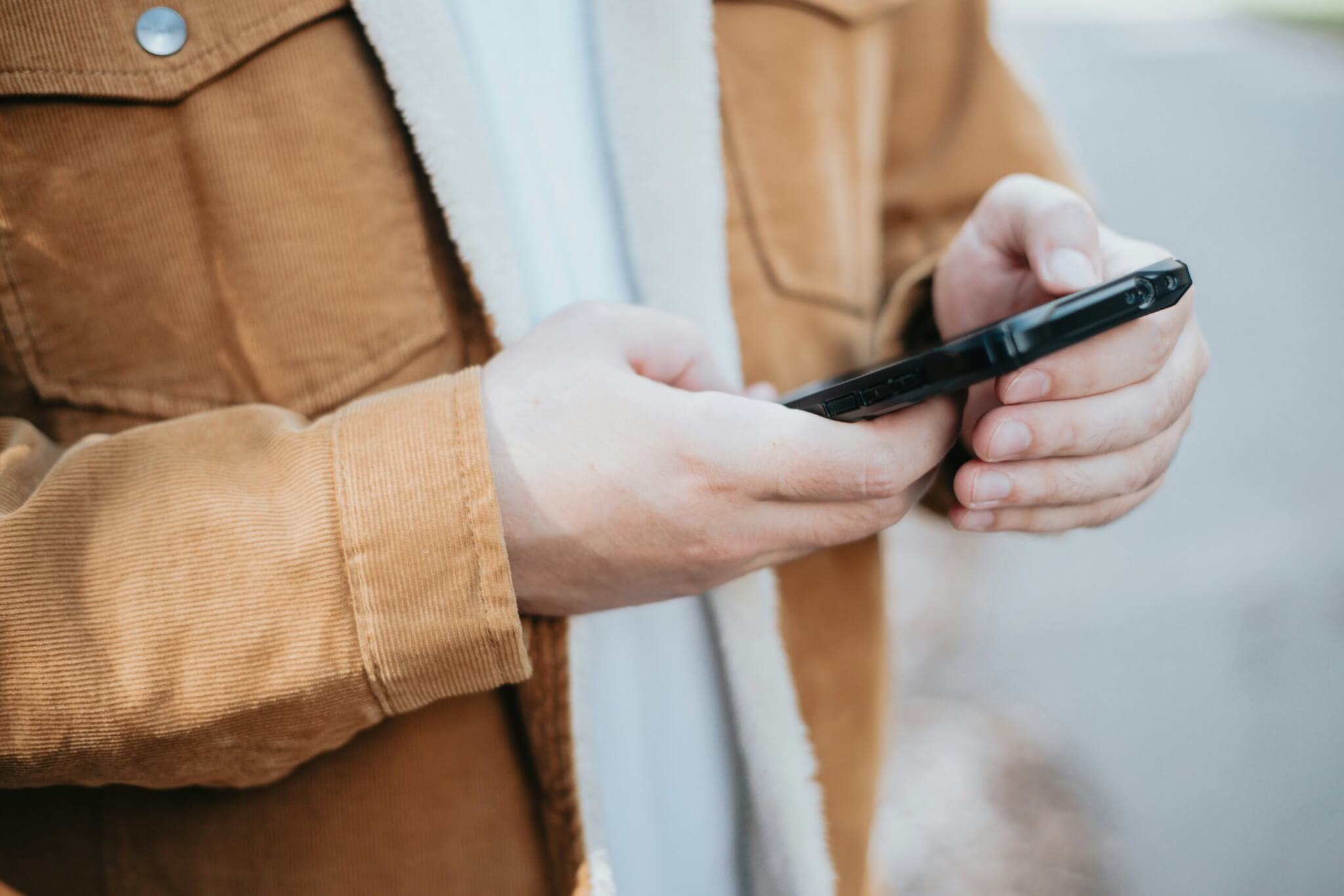 Man typing on a smart phone