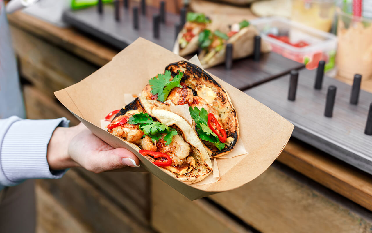 Street vendor hands making taco outdoors