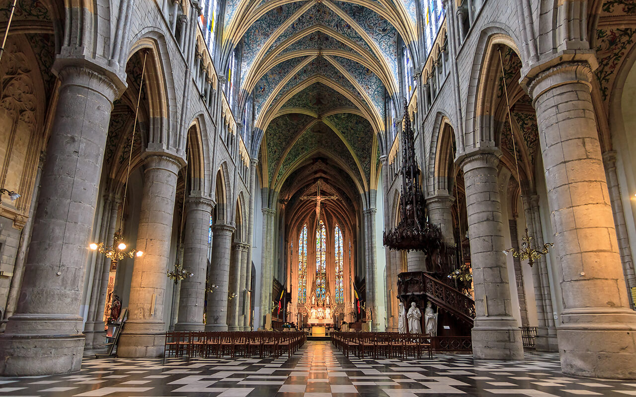 Interior of historic Gothic cathedral with stained glass windows and vaulted ceilings