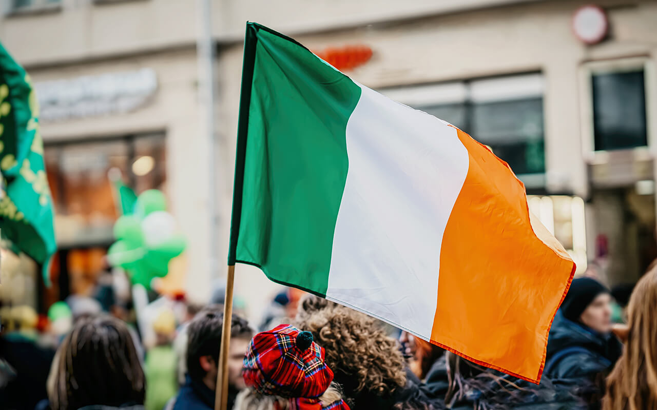 Irish flag waving in a parade crowd during St. Patrick’s Day celebrations in the United States