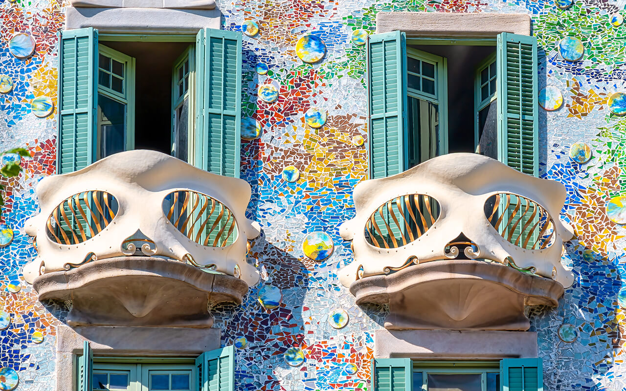 Casa Batlló in Barcelona with colorful mosaic facade and unique skeletal balconies, a stunning example of Gaudí’s modernist architecture.