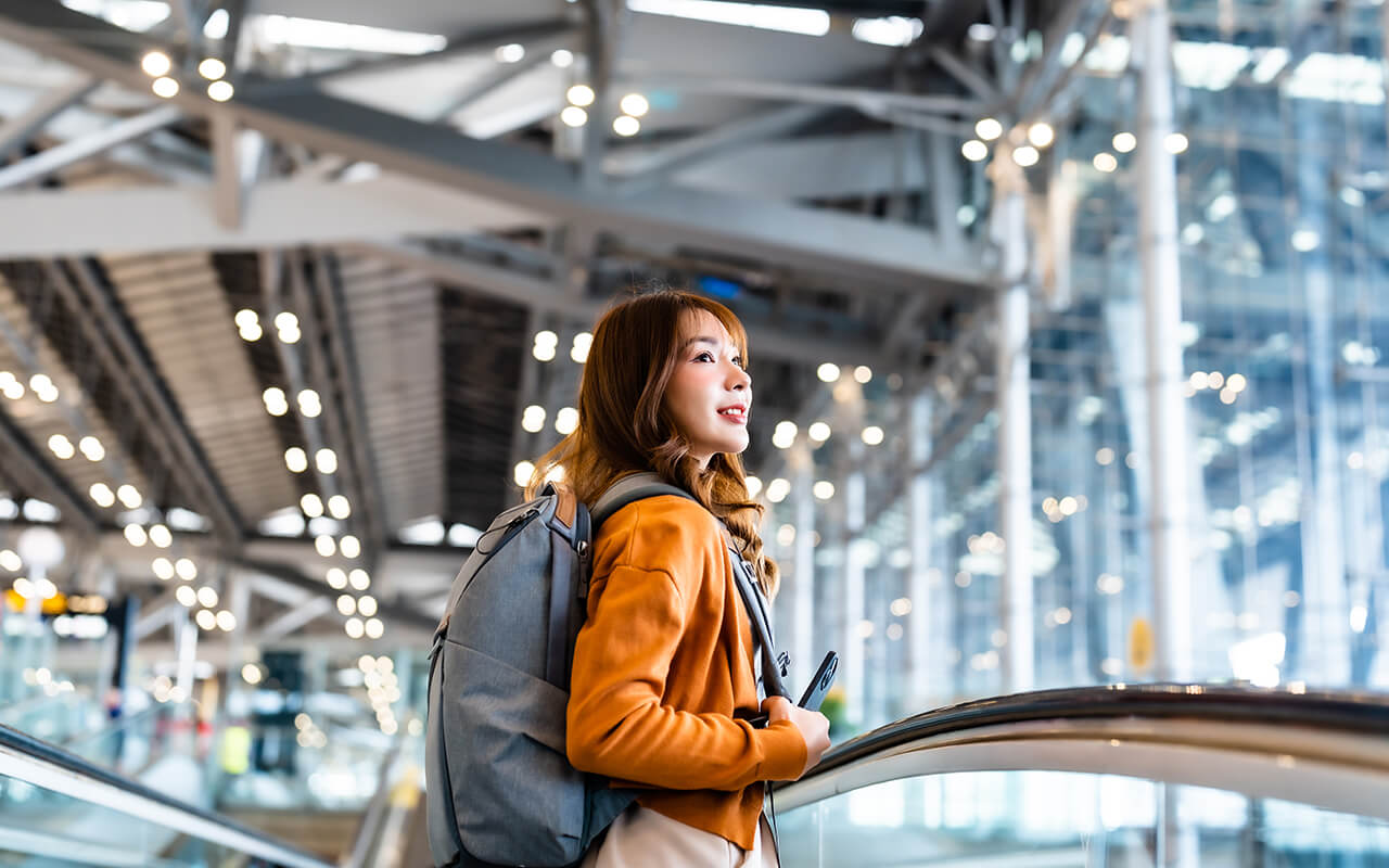 Young asian woman in international airport terminal or modern train station. 