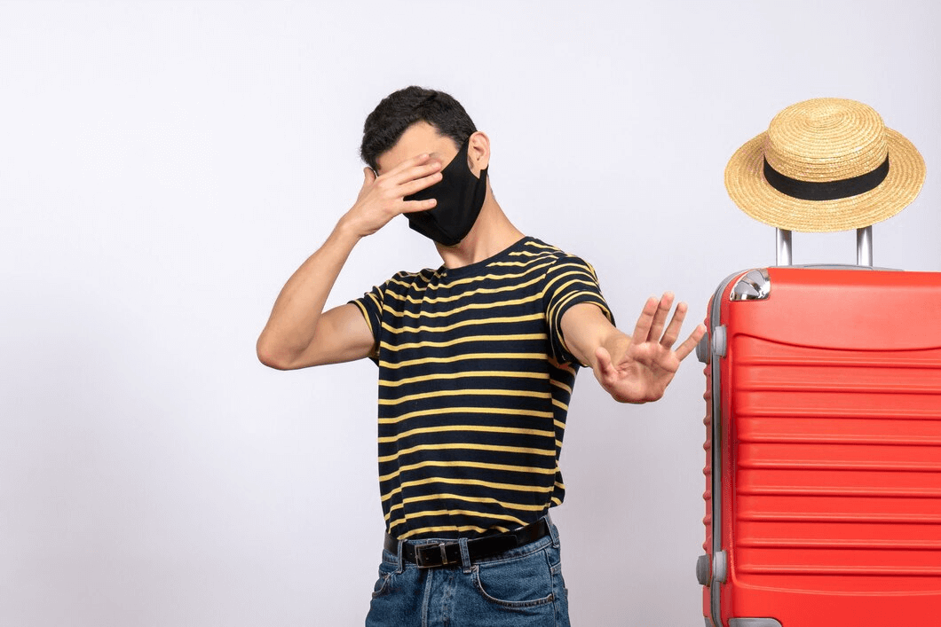 man with face mask and suitcase