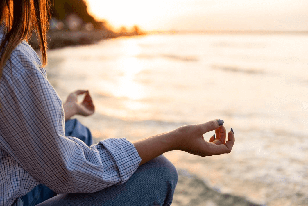 woman meditating by the ocean