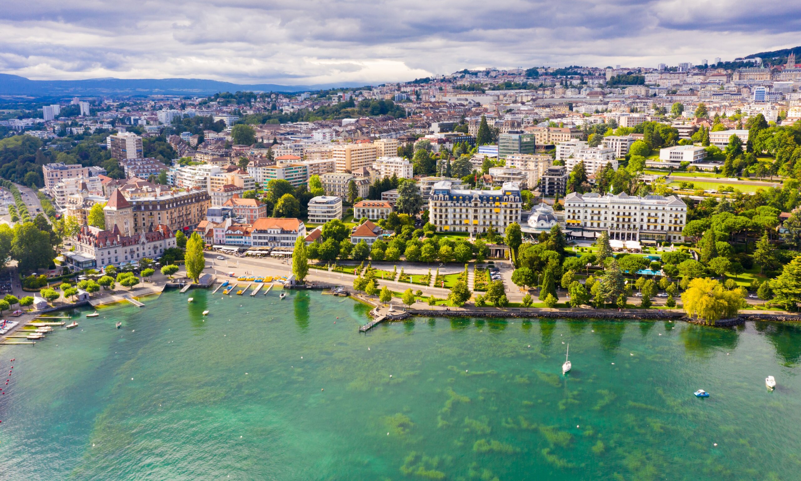 View from Lake Leman of residential areas of Swiss city of Lausanne in cloudy summer day, canton of Vaud in Romandy