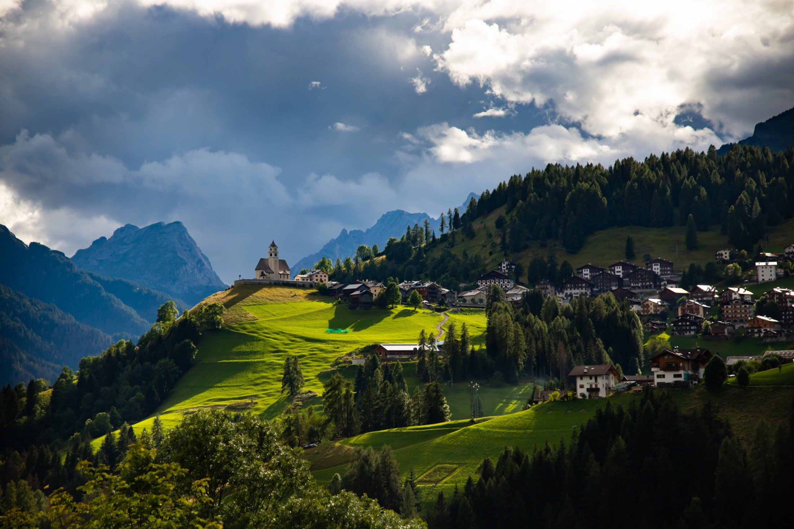 Picturesque view of Rocca Pietore village with a small church at the foot of Marmolada in the Dolomites