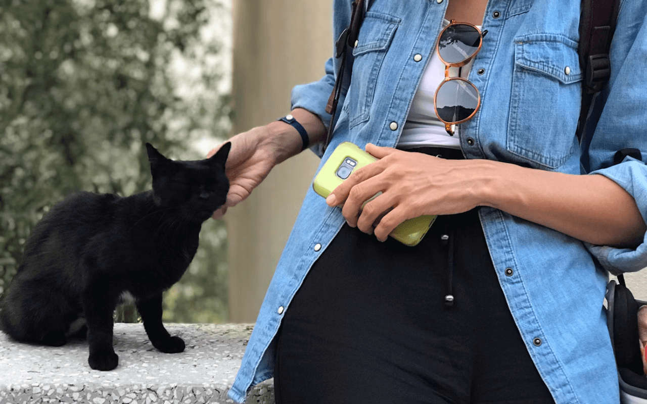 Woman petting a small black cat