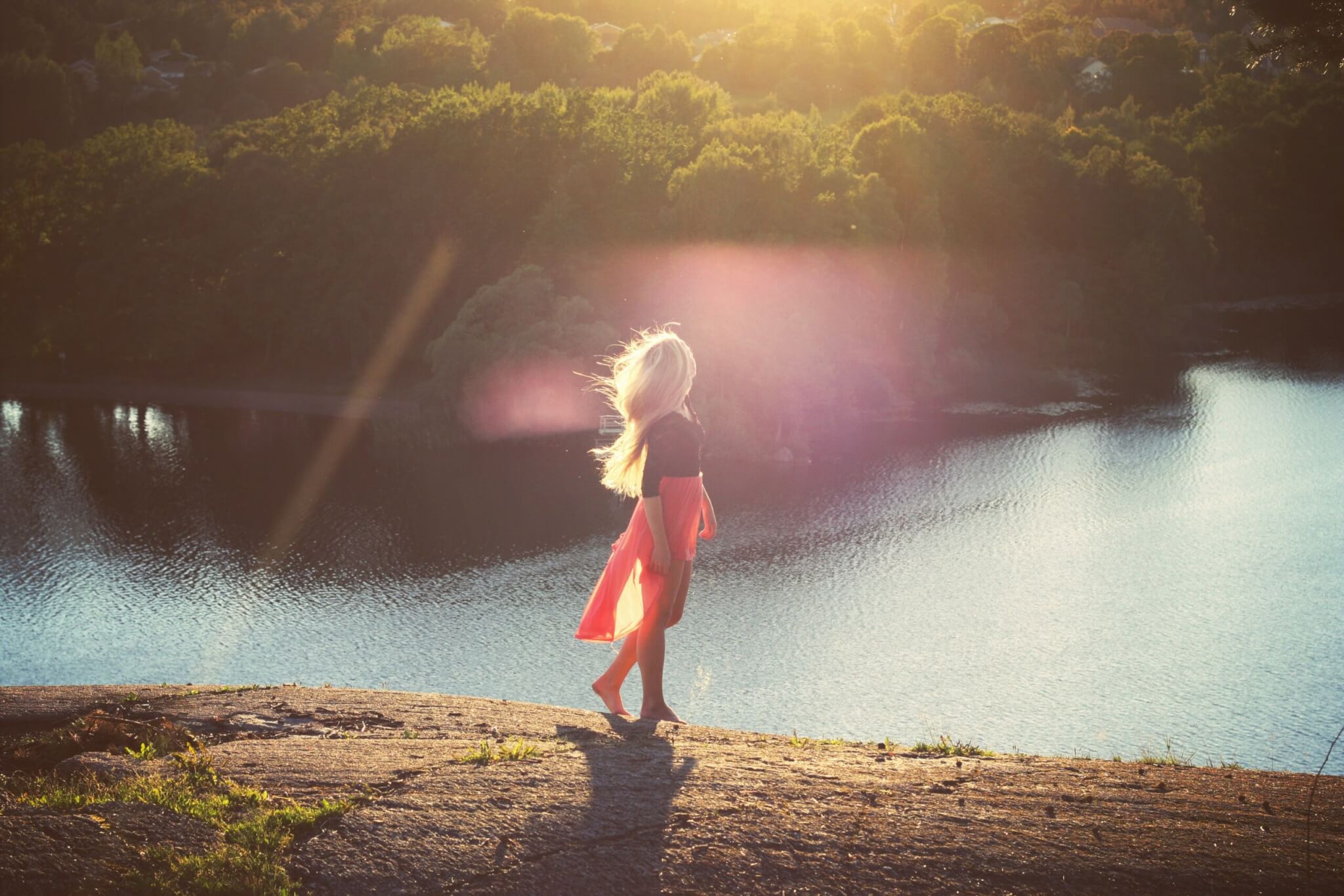 solo traveler standing by a lake at sunset, representing solo travel for introverts and quiet solo trips