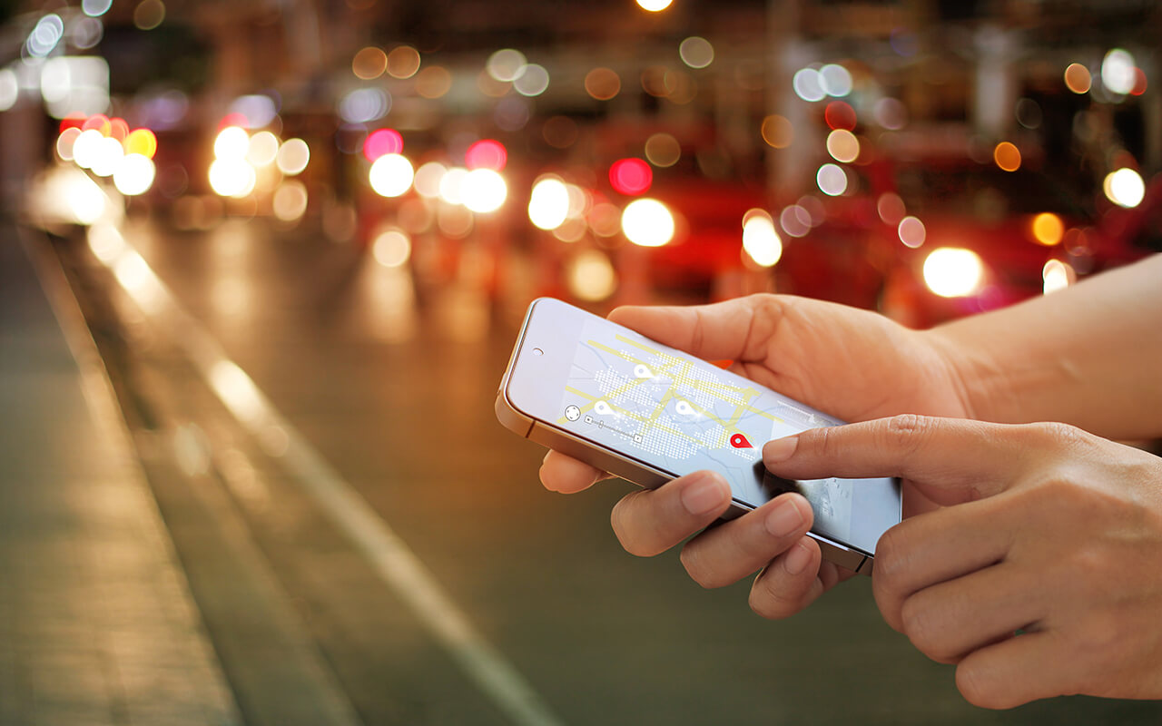 man using navigation app on the smartphone on street at night