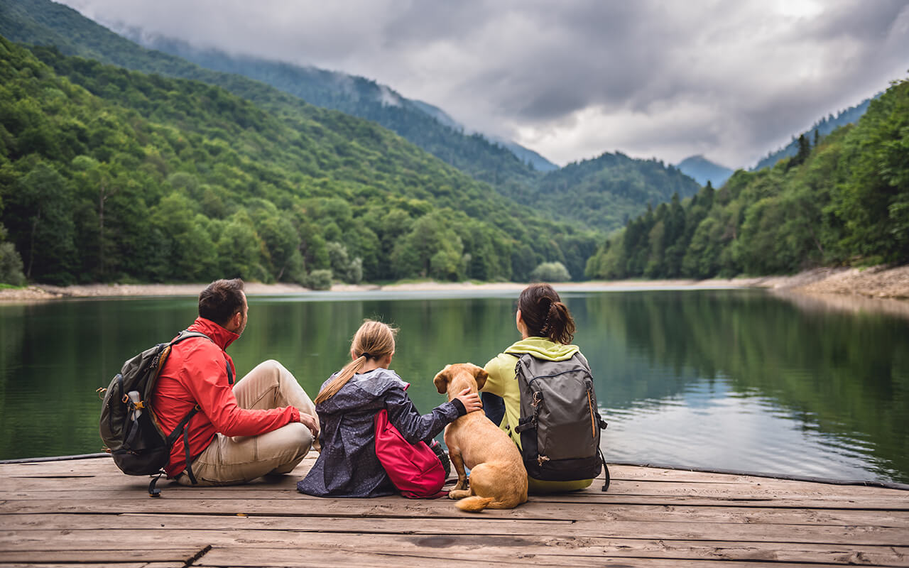 Family with dog resting on a pier