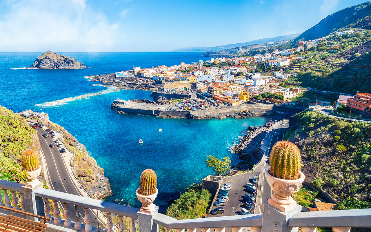 Coastal town and blue ocean view, representing the most beautiful islands in Spain and Spanish island getaways