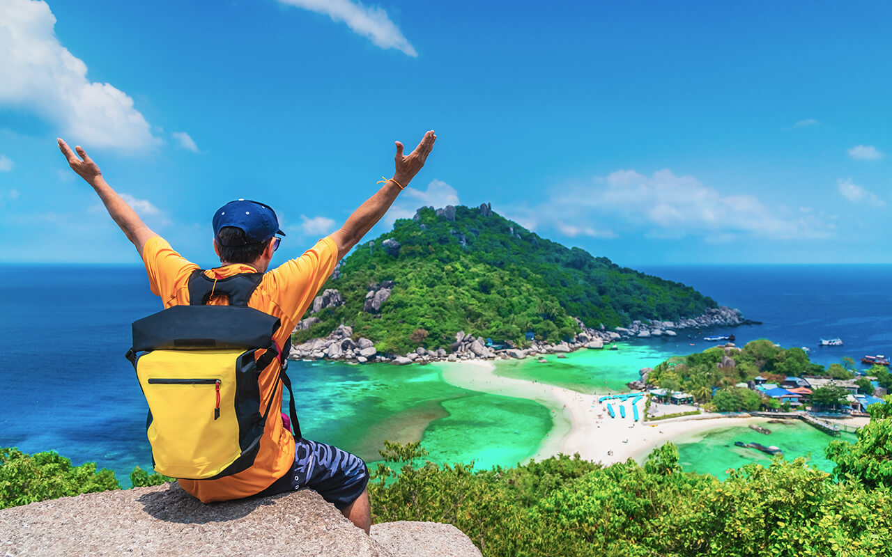 Man wearing a backpack traveling to a beach