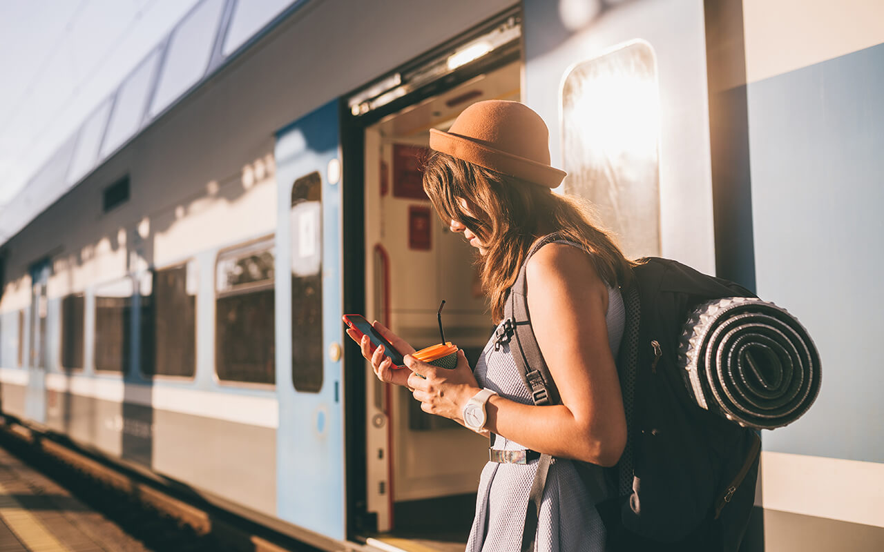 Woman in a hat stepping off of a train