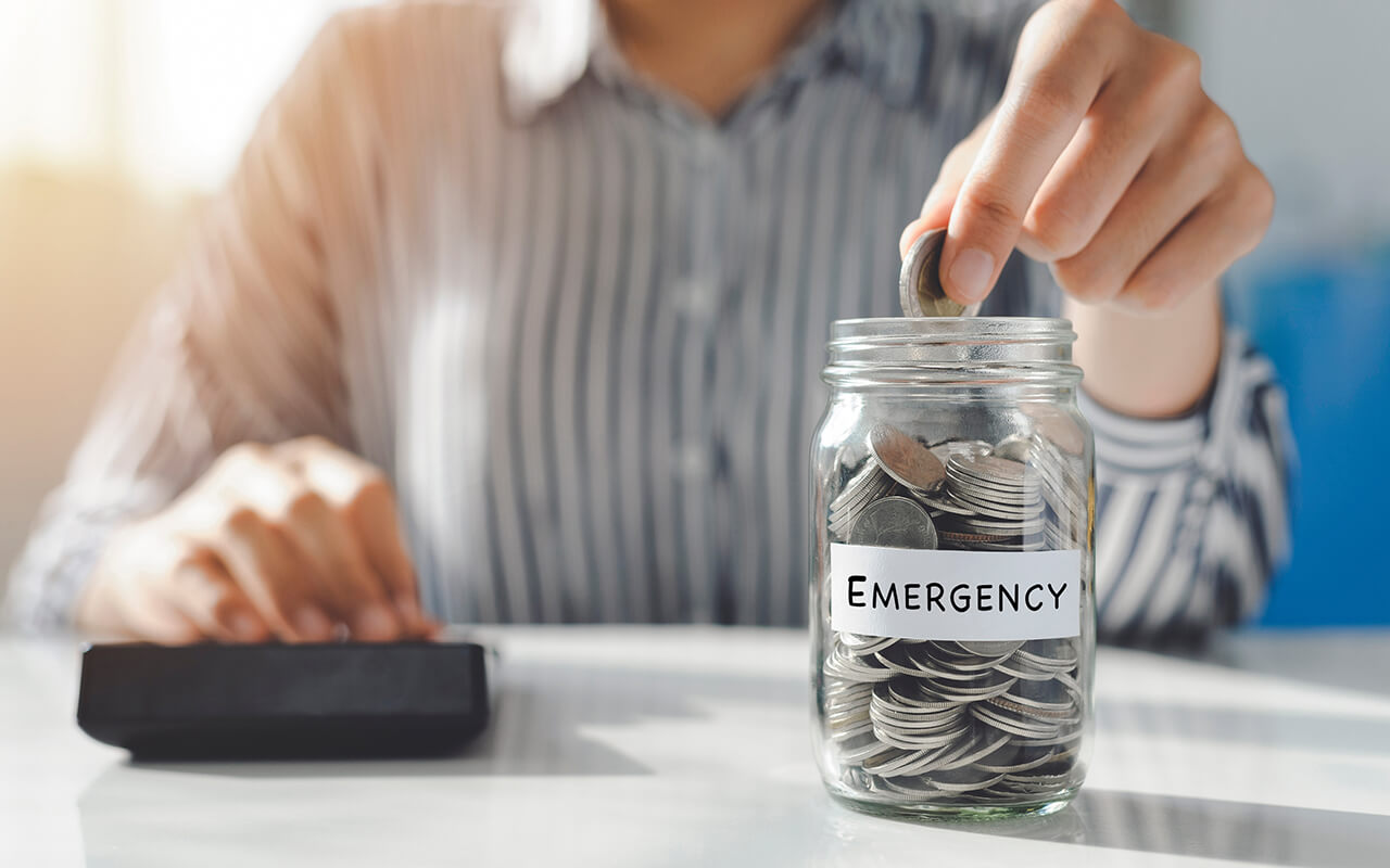 Coins in a jar labeled "Emergency" 