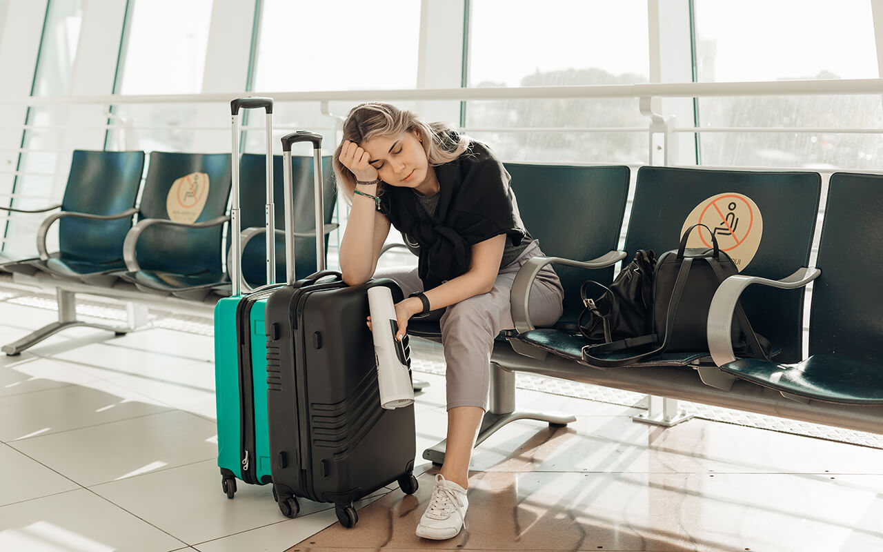 Stressed out woman at airport with luggage 