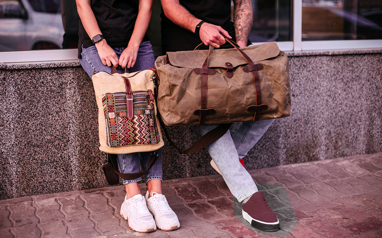 Woman and man holding canvas bags. Backpack and duffel canvas bag