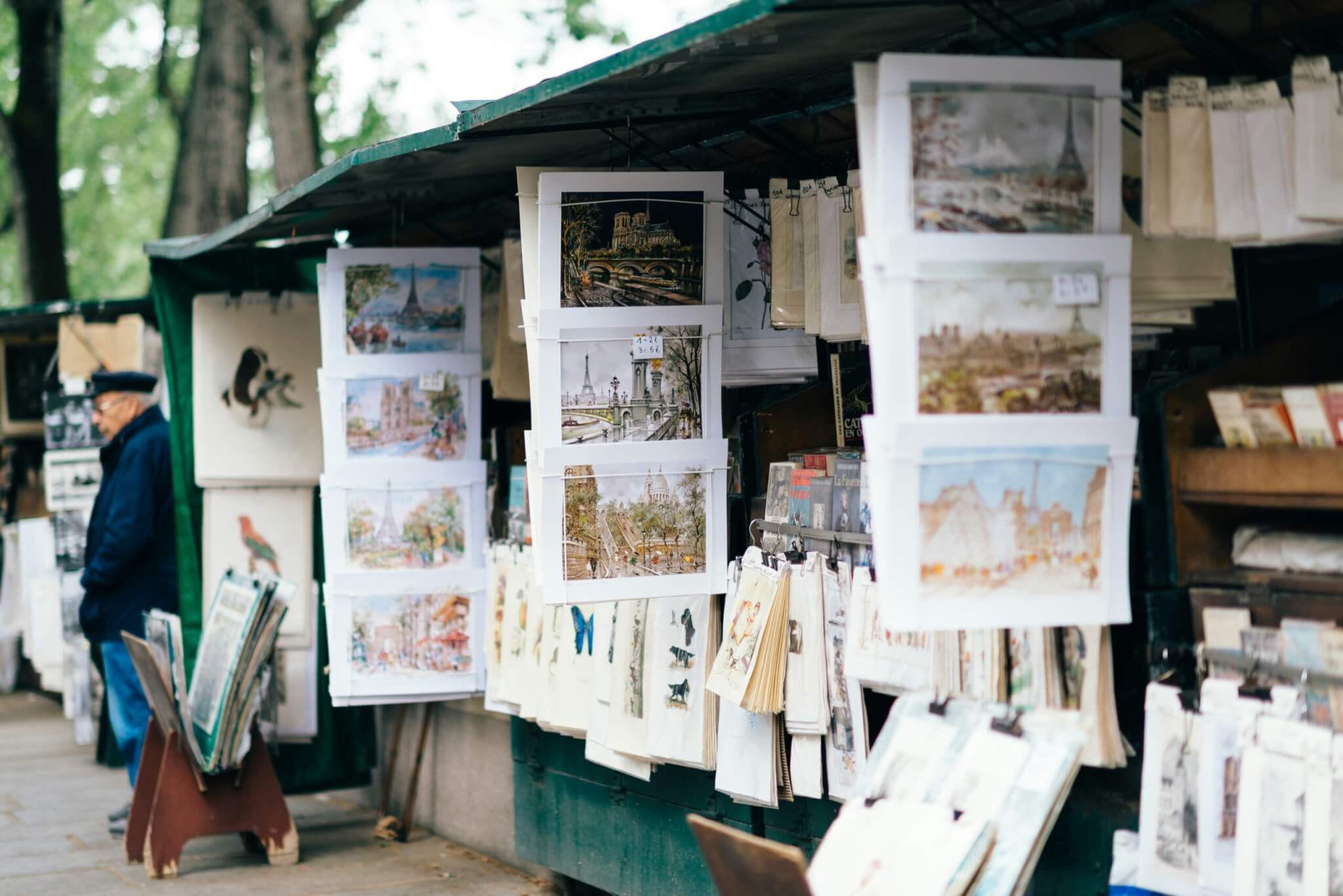 Art prints displayed at a Paris street stall near the Seine during solo travel in Paris