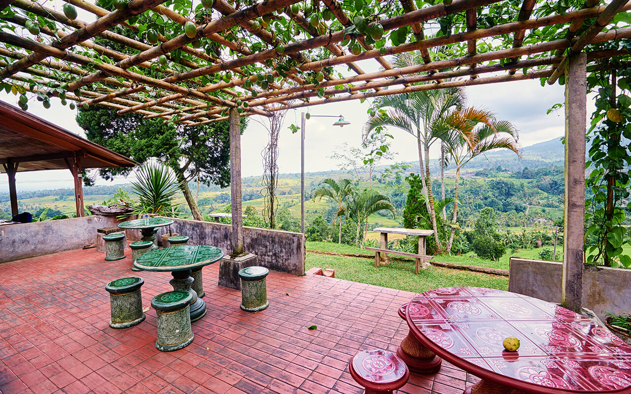 Scenic Outdoor Patio with Tables Overlooking Countryside Landscape and Greenery.