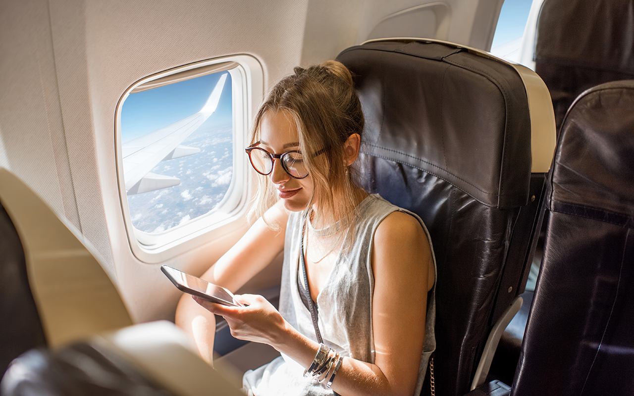 Woman looking at her phone on an airplane