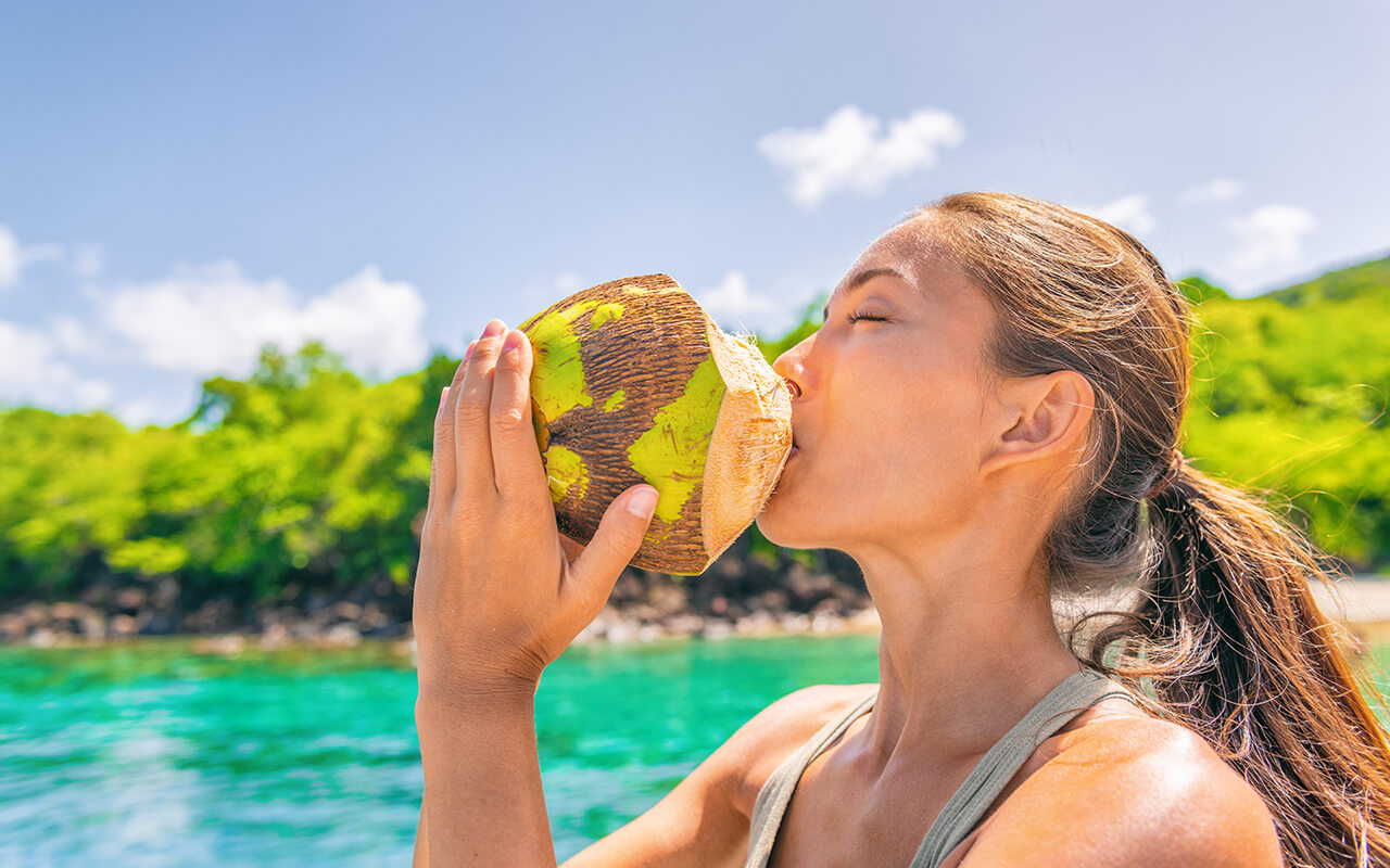 Woman drinking out of a coconut
