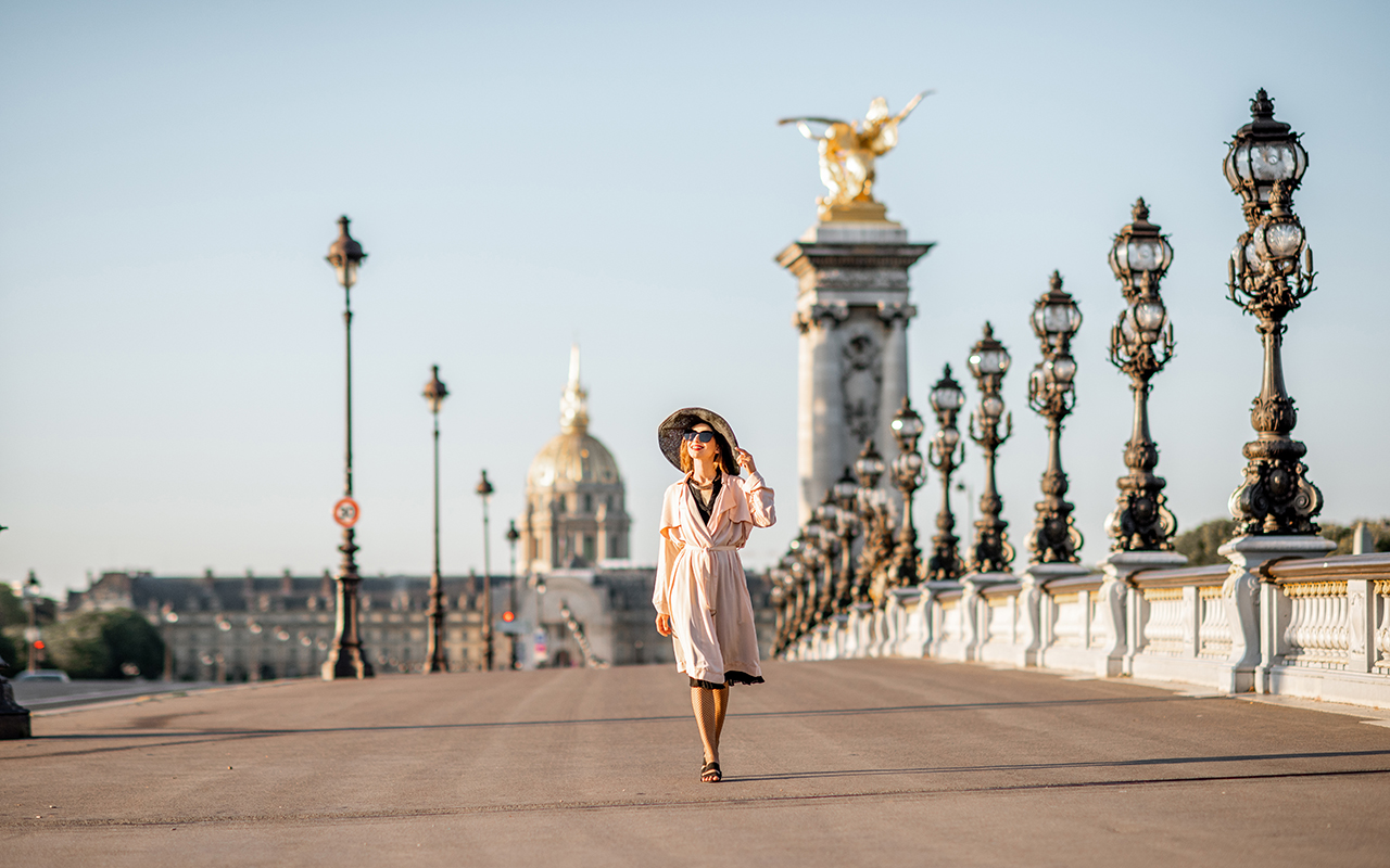 Woman in a dress walking down a city sidewalk