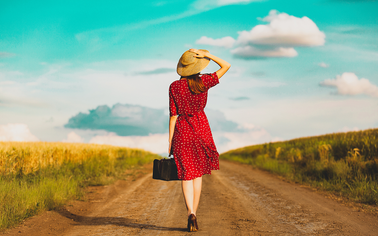 Woman walking with a suitcase, representing life changes before traveling and preparing for long-term travel